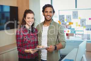 Male and female graphic designers holding digital tablet