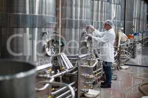 Factory engineer monitoring a pressure gauge of storage tank