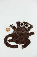 Coffee beans and cups forming monkey owl with cookie