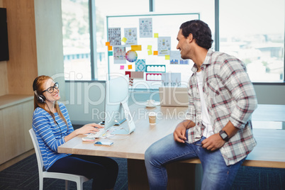 Graphic designers interacting with each other in conference room