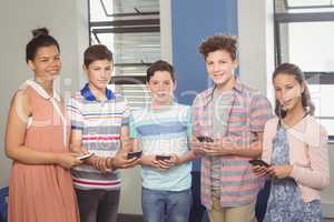 Students holding mobile phone in classroom