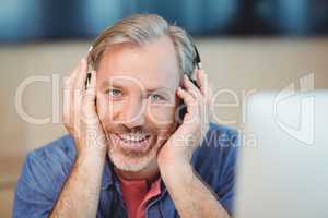 Male graphic designer listening music on headphones