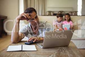 Tense man with hand on forehead sitting in living room