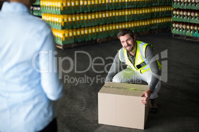 Factory worker picking up cardboard boxes in factory