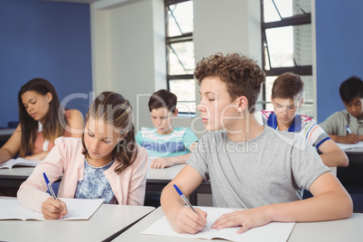 Attentive school kids doing homework in classroom