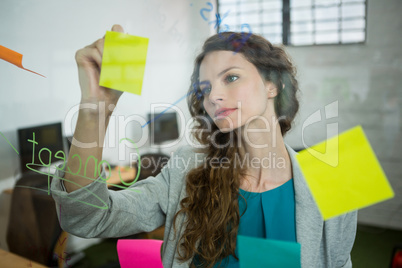 Female executive writing on sticky notes