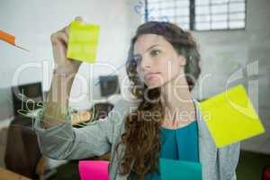 Female executive writing on sticky notes