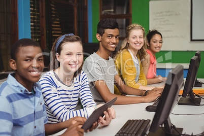 Portrait of smiling students studying in computer classroom