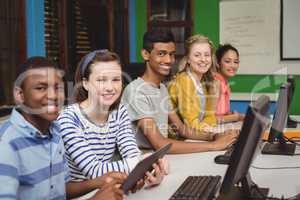 Portrait of smiling students studying in computer classroom