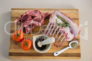 Rib rack, rib chop and ingredients on wooden board
