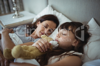 Mother and daughter sleeping in bed