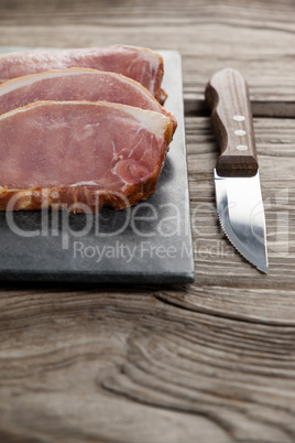 Sirloin chop on black slate plate with knife