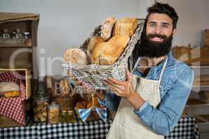 Portrait of male staff holding a basket of bread