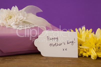 Happy mothers day card on gift box with flowers