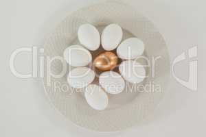 White and golden easter eggs in plate