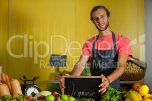 Portrait of male staff holding slate board in organic section