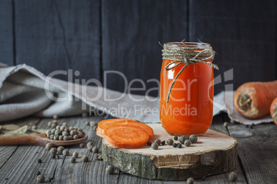 Glass jar with juice on a wooden surface
