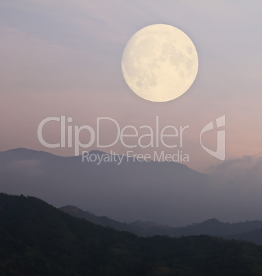 Big Moon over mountain in morning light.
