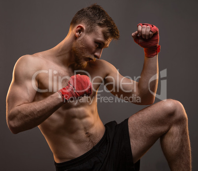 Muscular young boxer with leg up