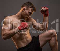 Muscular young boxer with leg up