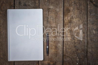 empty open notebook with pen on brown wooden surface