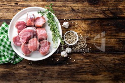 Fresh raw pork tenderloin, chopped meat on dark wooden rustic background, top view