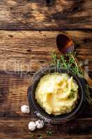 Mashed potatoes, boiled puree in cast iron pot on dark wooden rustic background, top view