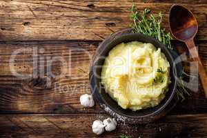 Mashed potatoes, boiled puree in cast iron pot on dark wooden rustic background, top view