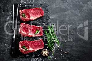 Raw meat, beef steak on black background, top view