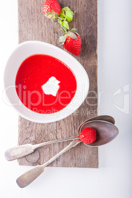 Strawberry soup with a spoon on a table.