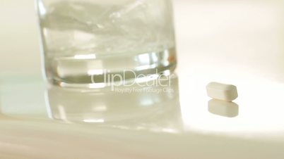 Pan of Pill, Water Pouring Into Glass and Various Fictitious Non-proprietary Prescription Medicine Bottles.