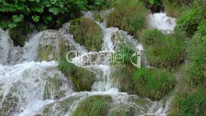 Green Grass and a Waterfall. Slow Motion