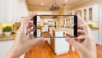 Female Hands Holding Smart Phone Displaying Photo of Kitchen Beh