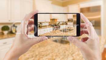 Female Hands Holding Smart Phone Displaying Photo of Kitchen Beh