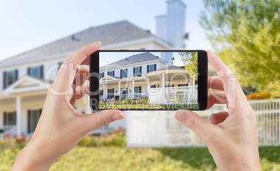 Female Hands Holding Smart Phone Displaying Photo of House Behin