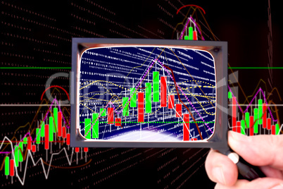 Hand holding magnifying glass in front of chart