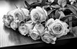 A bouquet of roses on the table. Black-and-white image.