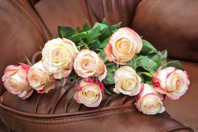 Bouquet of roses lies on the surface of the chair.