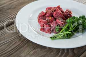 Diced beef and corainder leaves in white plate