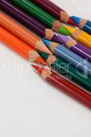 Colored pencils arranged in interlock pattern on white background