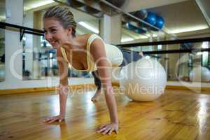 Smiling fit woman exercising on fitness ball