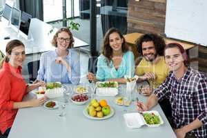 Smiling business executives having meal in office