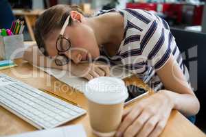 Overworked graphic designer sleeping on his desk