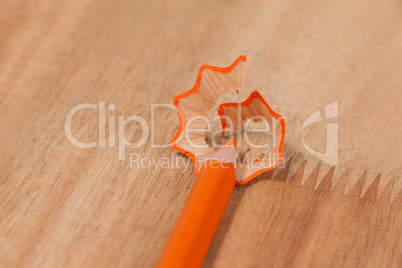 Close-up of orange colored pencil with shavings