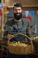 Vendor holding basket of potatoes at the grocery store