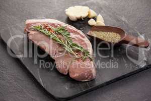 Sirloin chop, garlic and spices on black slate plate