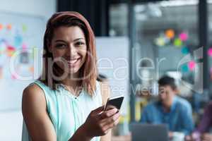 Business executive using mobile phone in office