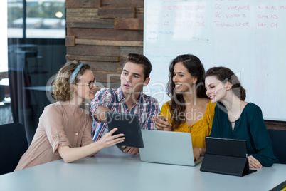 Business executives discussing over digital tablet