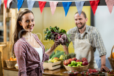 Woman holding beetroot at the counter in the grocery store