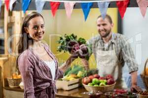 Woman holding beetroot at the counter in the grocery store